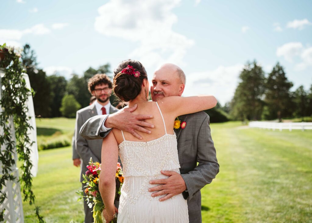 NH New England Rockingham Country Club wedding summer seacoast photographer  New Hampshire orange  wild flowers bride walking down the aisle with father