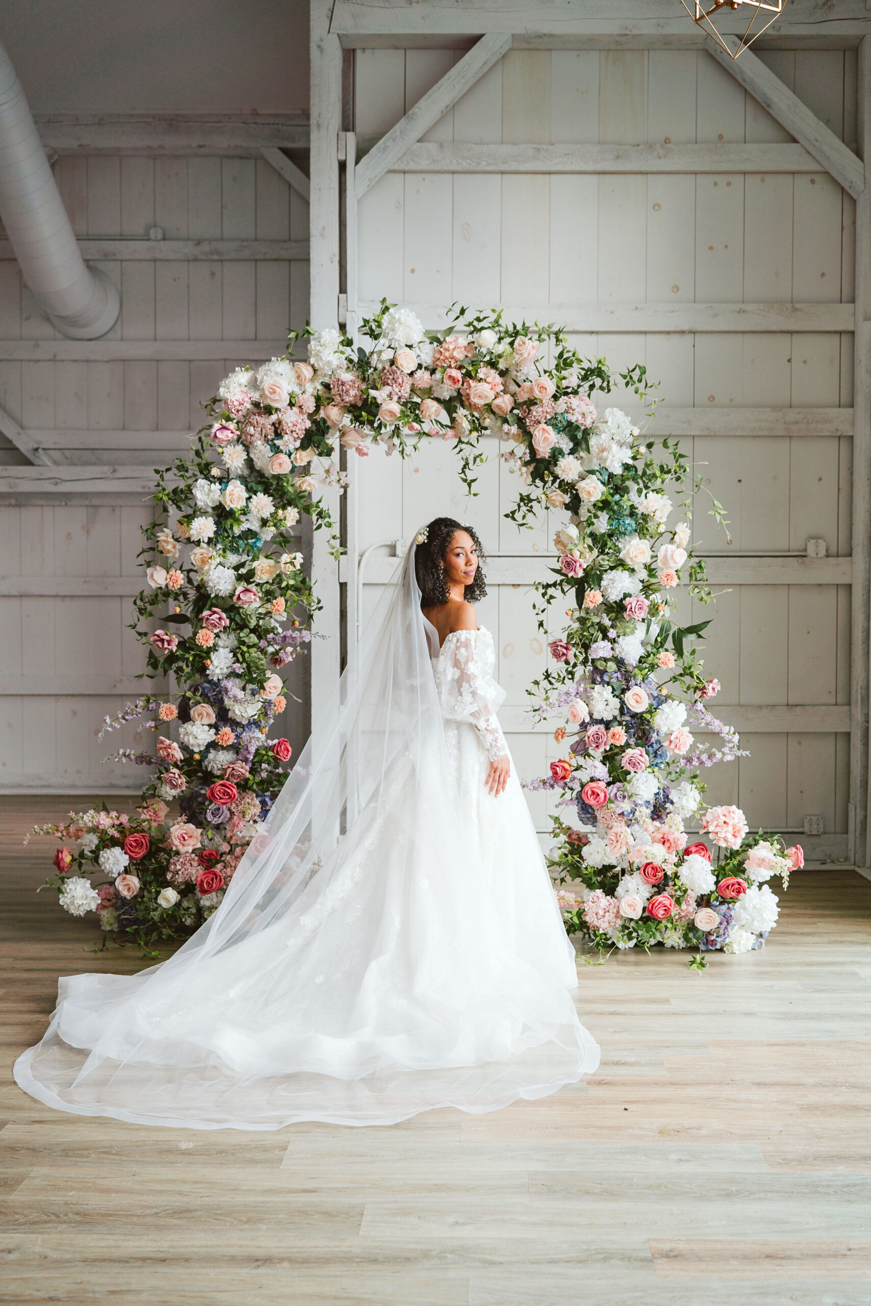 pink flowers / flower arbor / arbour / pretty / best new england photographer / best wedding photographer / new hampshire wedding / pink wedding flowers / close up portrait / head over shoulder pose / pink floral dress / black bride